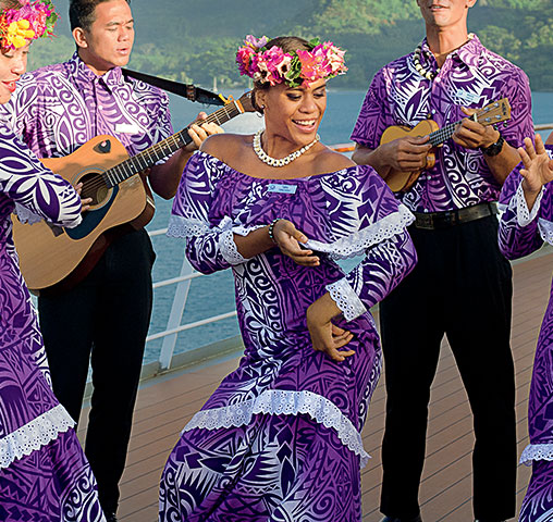 A Gauguine dancer dancing to acoustic Poynesian music played by two Gauguins.