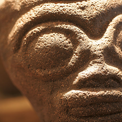 A tiki face carved into stone.
