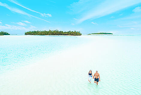 Paul Gauguin Cruises | Couple strolling sandbar in Society Islands